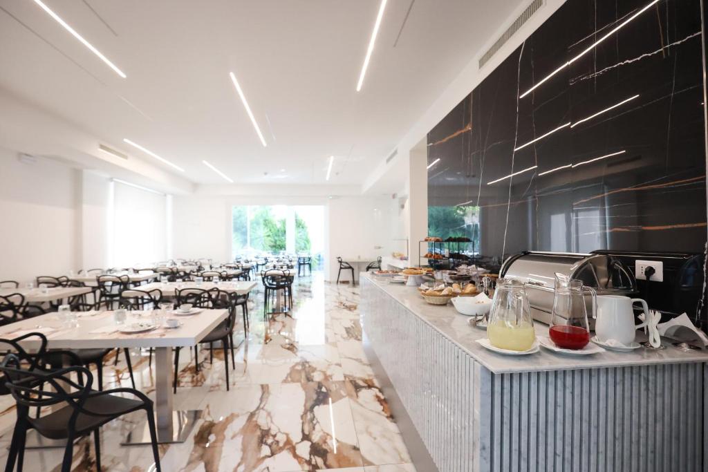 un restaurant avec des tables et des chaises et un comptoir avec de la nourriture dans l'établissement Hotel Cenisio, à Rimini