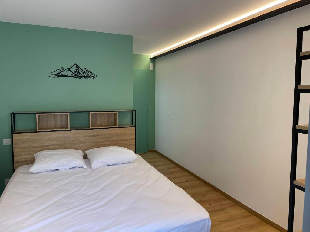 - une chambre dotée d'un lit avec des draps blancs dans l'établissement LE CHOUCAS - LA MONGIE, à Bagnères-de-Bigorre