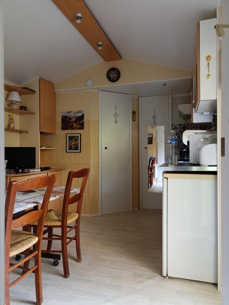 une cuisine et une salle à manger avec une table et des chaises dans l'établissement Mobil home, à Villefranche-de-Conflent
