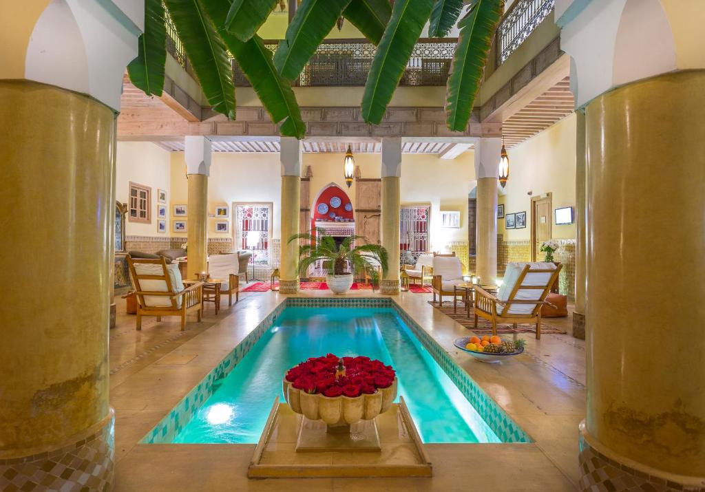 - une piscine avec un bol de fleurs dans la chambre dans l'établissement Riad Azoulay, à Marrakech