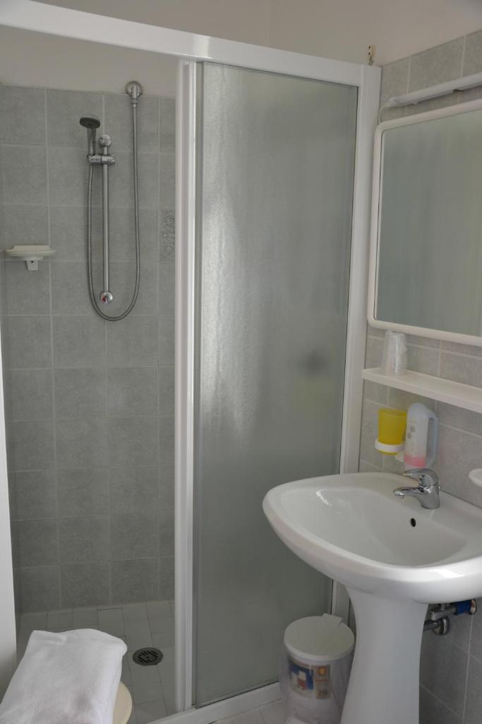 une salle de bain avec douche et lavabo dans l'établissement Hotel Stockholm, à Lido di Jesolo
