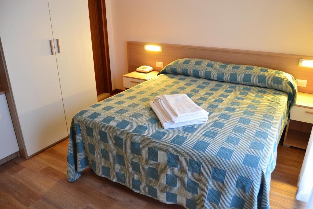 une chambre avec un lit avec deux serviettes dessus dans l'établissement Hotel Midi, à Lido di Jesolo