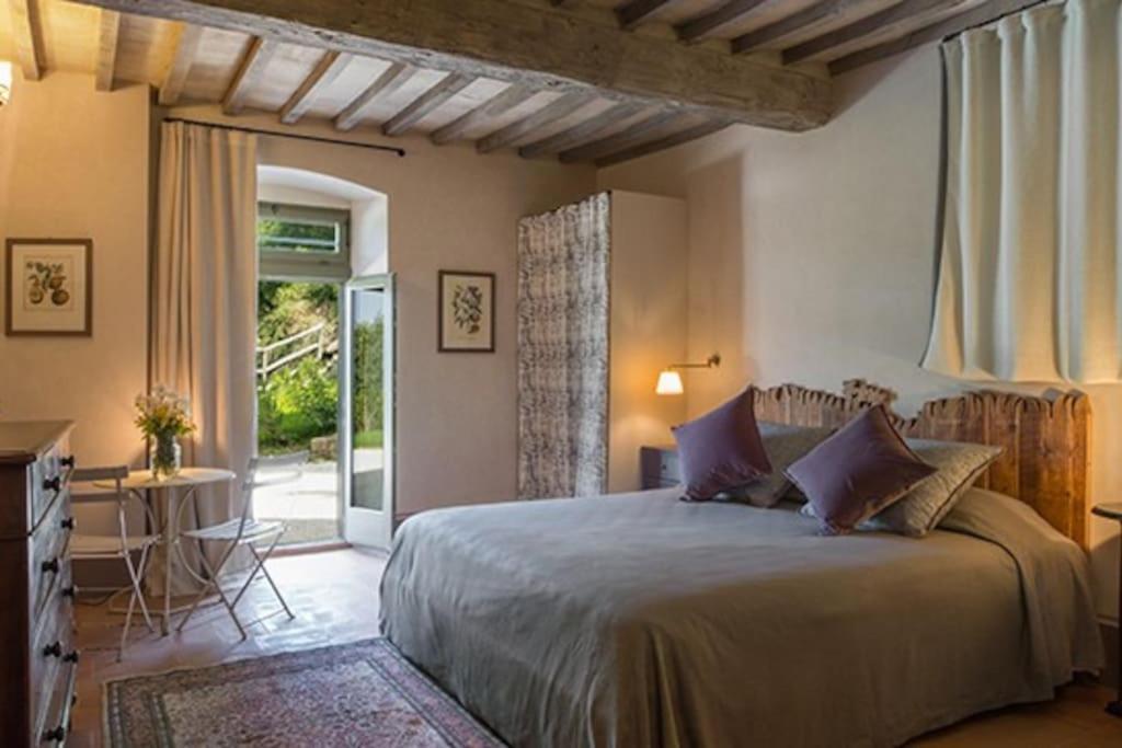 une chambre avec un grand lit et un patio dans l'établissement Villa Leopoldina - Pomaio Wines & Hospitality, à Arezzo