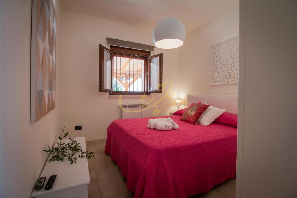 - une chambre avec un lit rose et une couverture rose dans l'établissement TD Villa Luna Trulli with Large Pool, à Castellana Grotte
