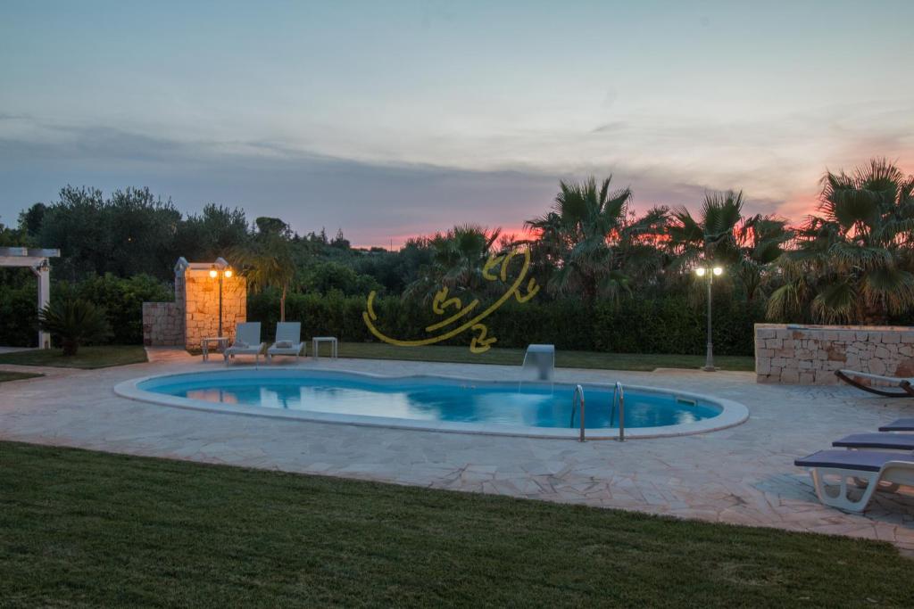 - une piscine dans une cour avec un coucher de soleil dans l'établissement TD Villa Luna Trulli with Large Pool, à Castellana Grotte