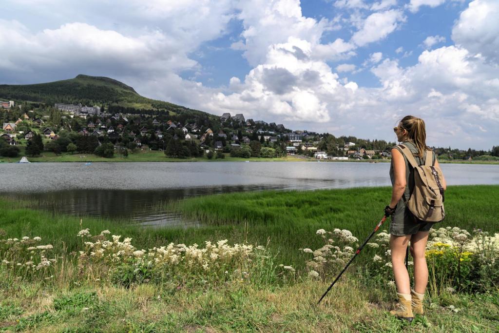 une femme debout dans l'herbe près d'un lac dans l'établissement Belambra Clubs Superbesse - Le Chambourguet, à Super-Besse