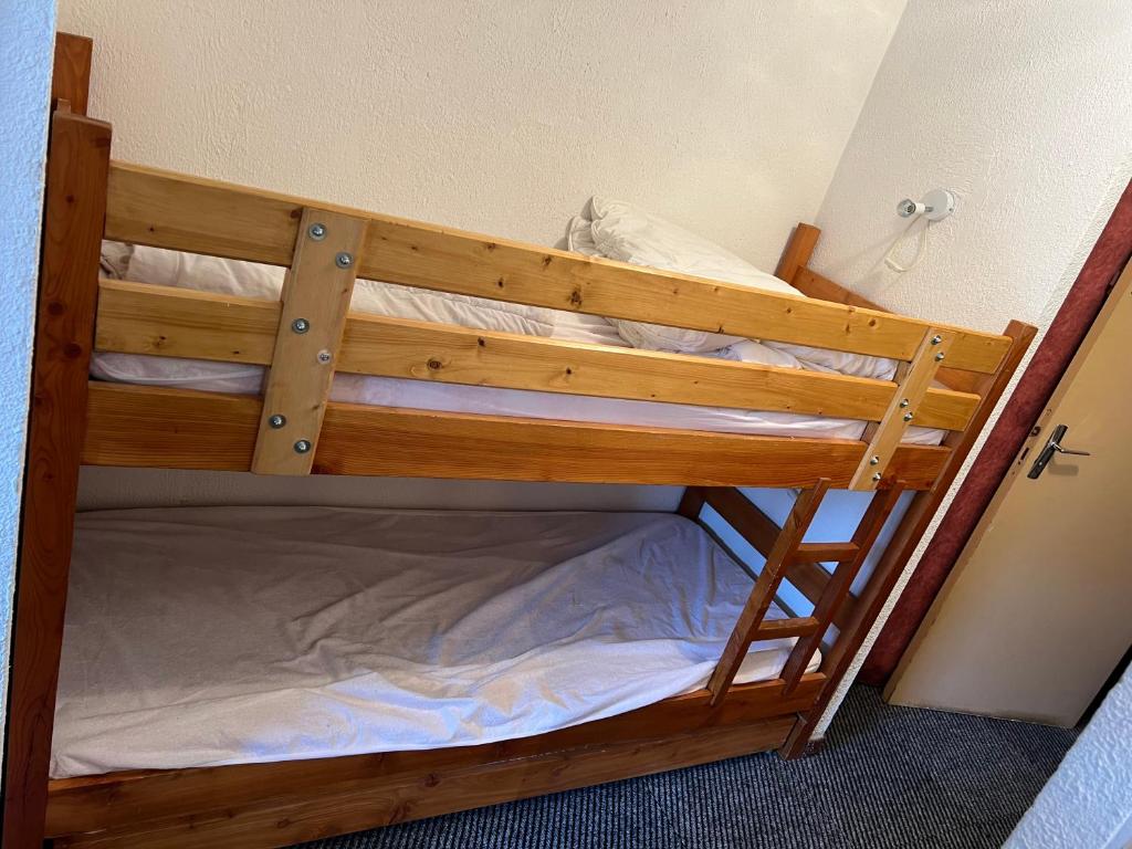 Ce lit superposé en bois se trouve dans une petite chambre. dans l'établissement Orcières-Merlette le Panoramic, à Orcières