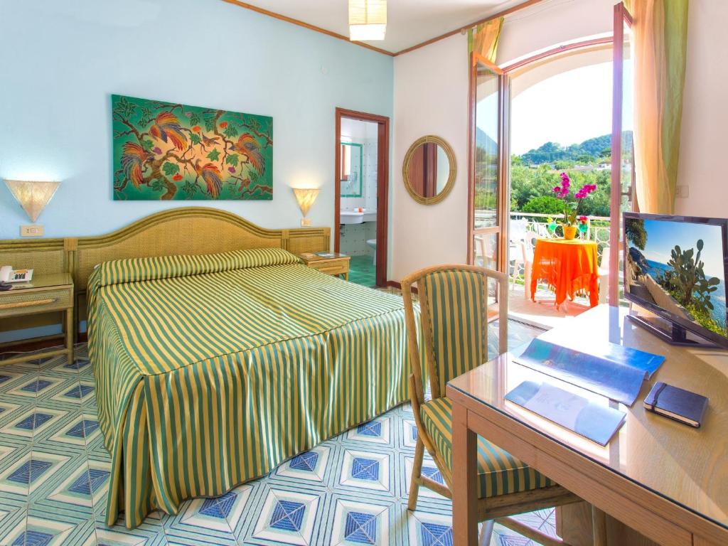 une chambre d'hôtel avec un lit, un bureau et un ordinateur dans l'établissement Hotel La Scogliera, à Ischia 172 autres photos