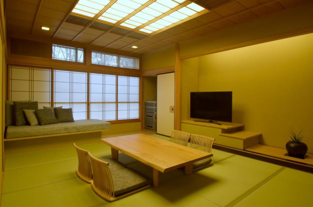 un salon avec une table et une télévision dans l'établissement Suizantei Club Jozankei-Adults Only, à Jozankei