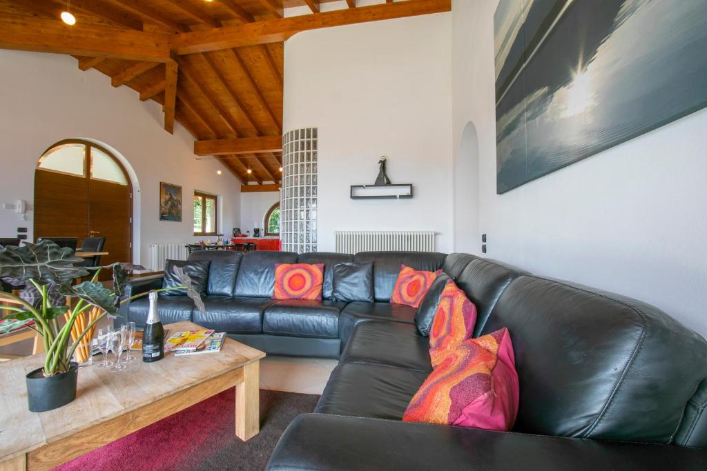 un salon avec un canapé en cuir noir et une table dans l'établissement Villa Louise, à San Siro 37 autres photos