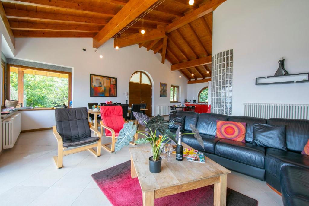 un salon avec un canapé en cuir noir et une table dans l'établissement Villa Louise, à San Siro