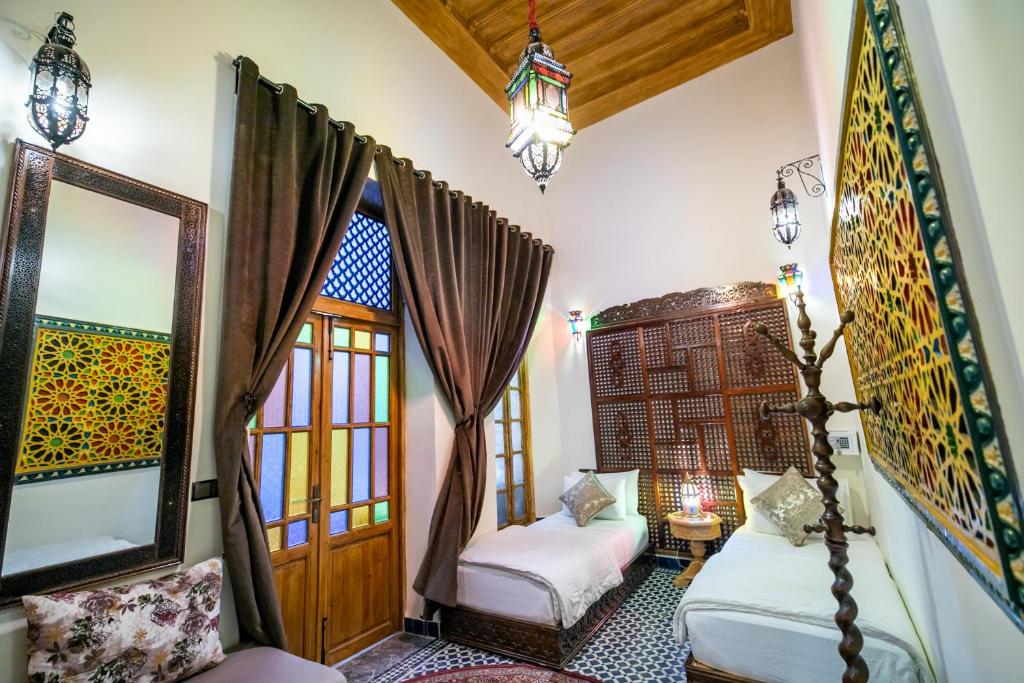 Cette chambre comprend 2 lits et un miroir. dans l'établissement Riad Diamant De Fes, à Fès