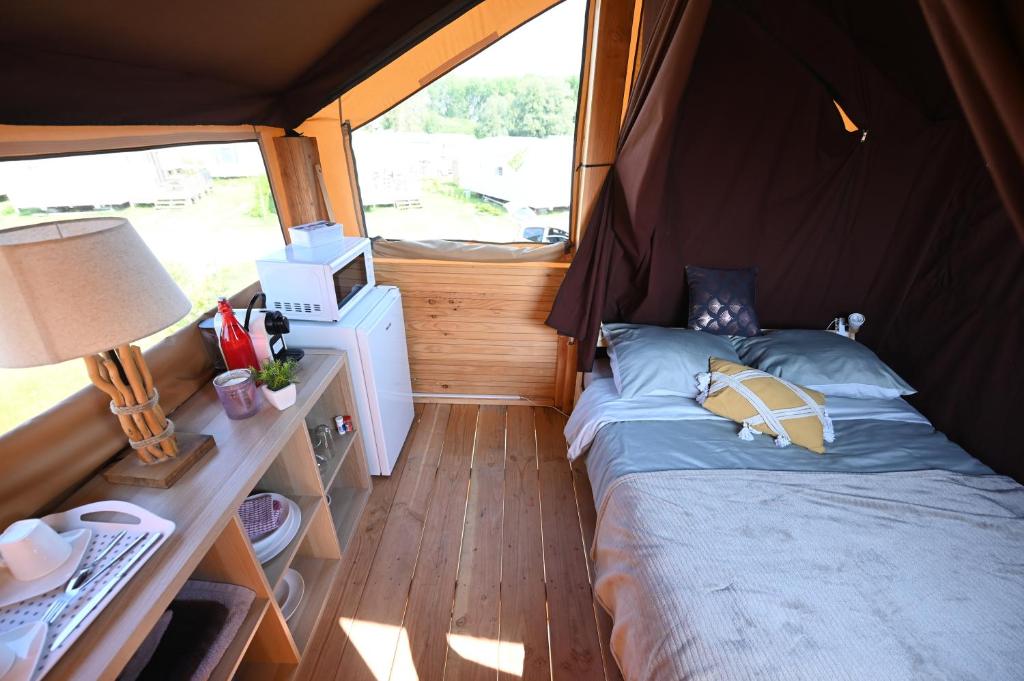 - une petite chambre avec un lit dans une tente dans l'établissement Domaine de la Roselière, à Noyelles-sur-Mer