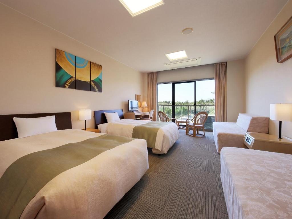 une chambre d'hôtel avec deux lits et un canapé dans l'établissement Senri no Kaze, à Tateyama 35 autres photos