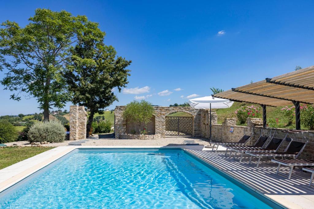 une piscine avec des chaises et un parasol dans l'établissement Grano - Casa Bella Vista, à Force
