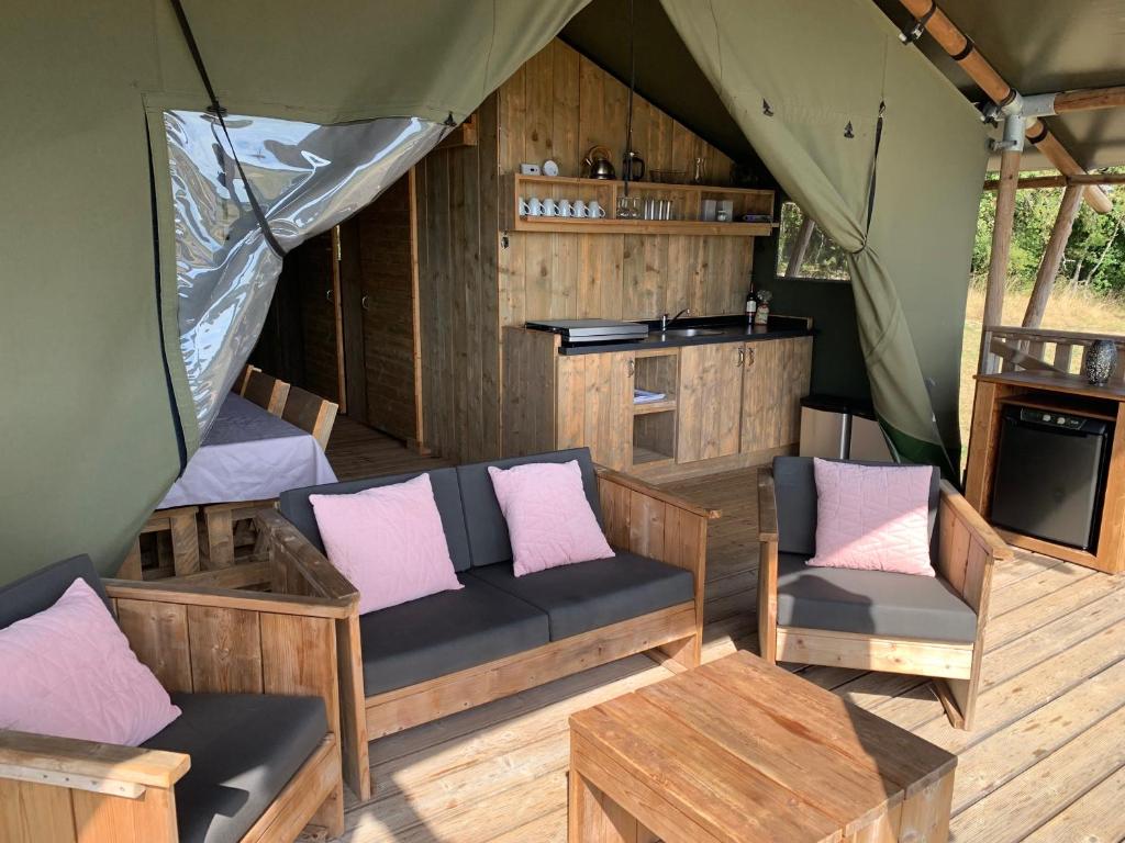 - un coin salon dans une tente avec des canapés et des tables dans l'établissement Safari tent lodges with a beautiful view at Lot Sous Toile, à Montamel