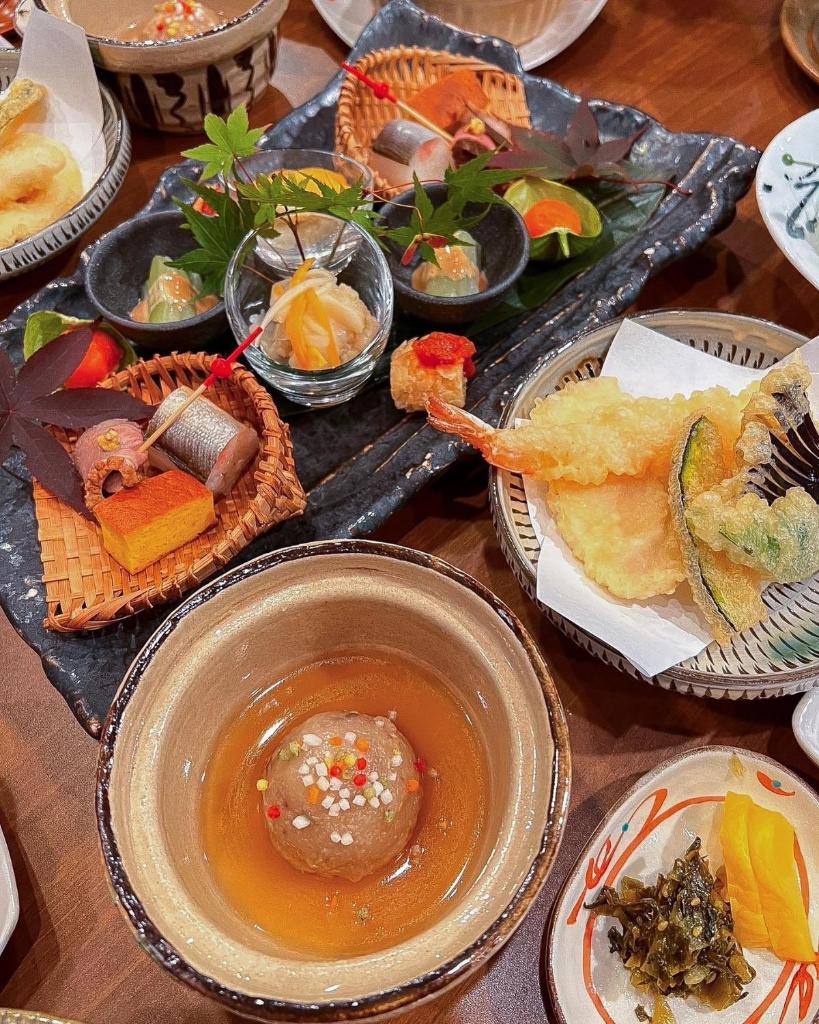 une table contenant de nombreux types de denrées alimentaires différents dans l'établissement Ryokan Yamanami, à Yufu