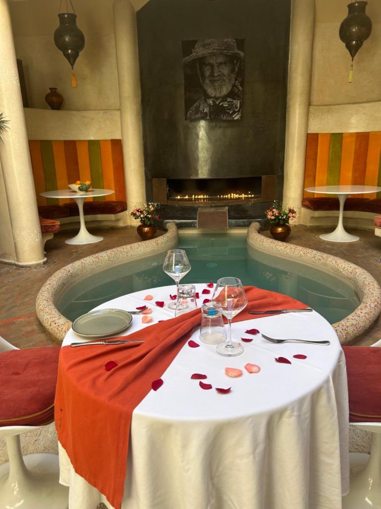 - une table à manger avec des verres à vin et une piscine dans l'établissement MAISON MK Adults ONLY - Music Riad, à Marrakech