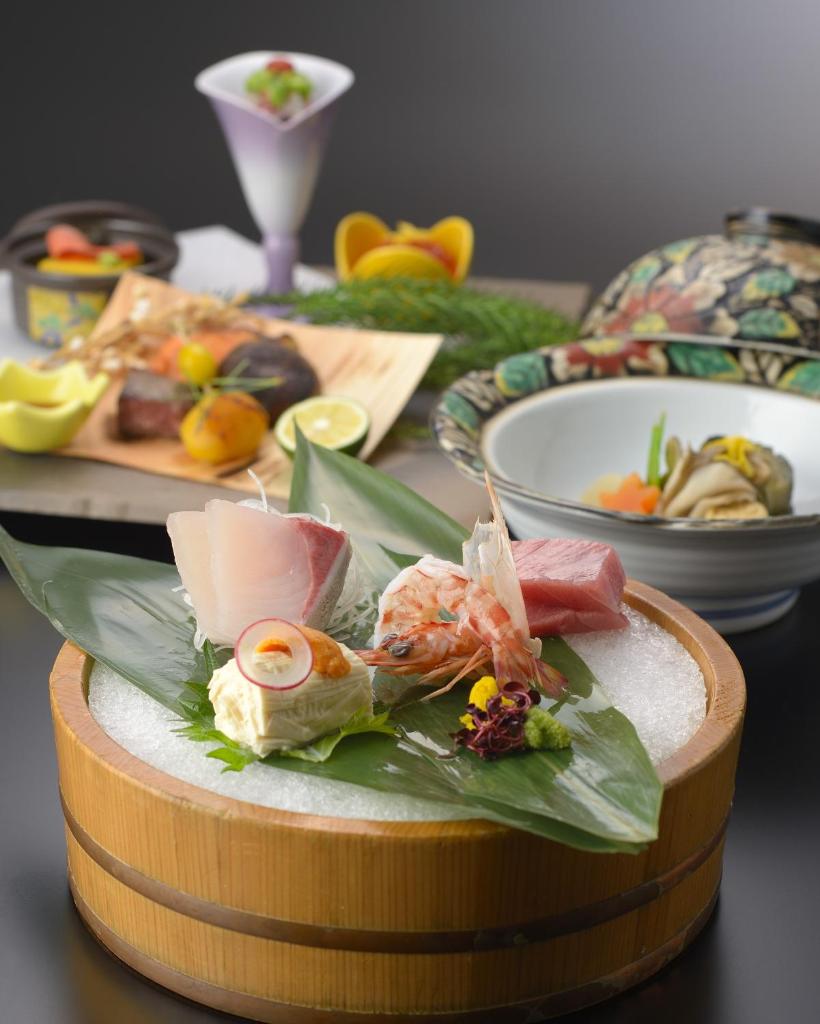 une table avec des assiettes de nourriture sur une table dans l'établissement Kinugawa Onsen Hana no Yado Matsuya, à Nikkō