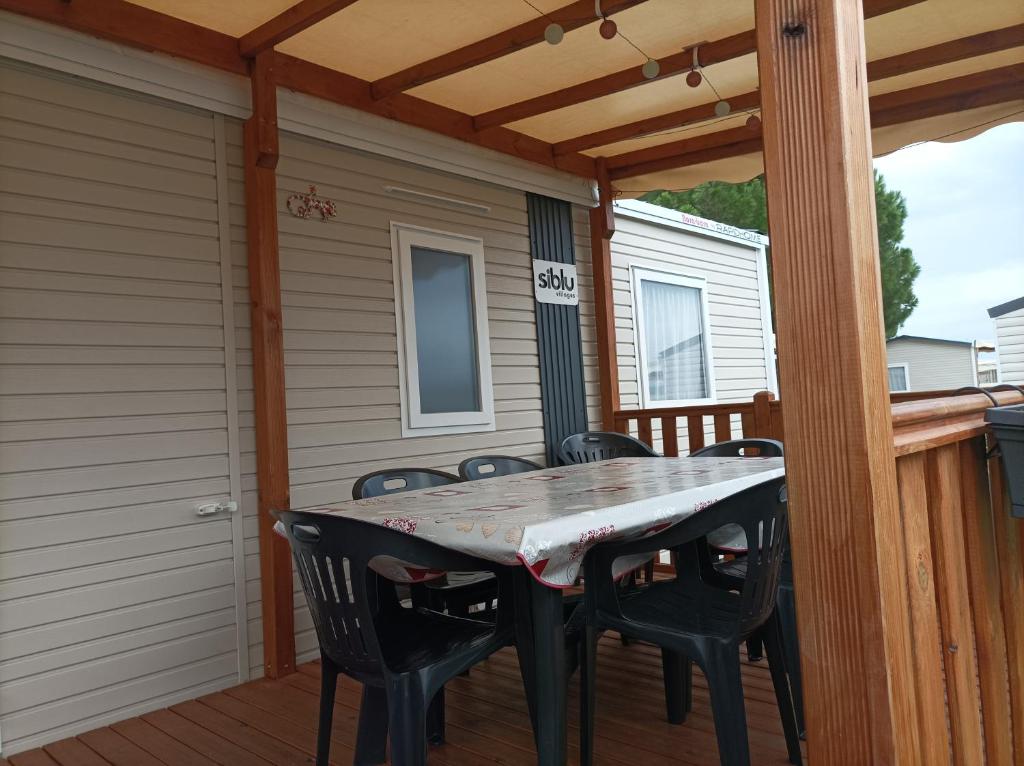 d'une terrasse avec une table et des chaises. dans l'établissement Mobil home moderne neuf et ultra équipé de 6 à 8 couchages, à Canet