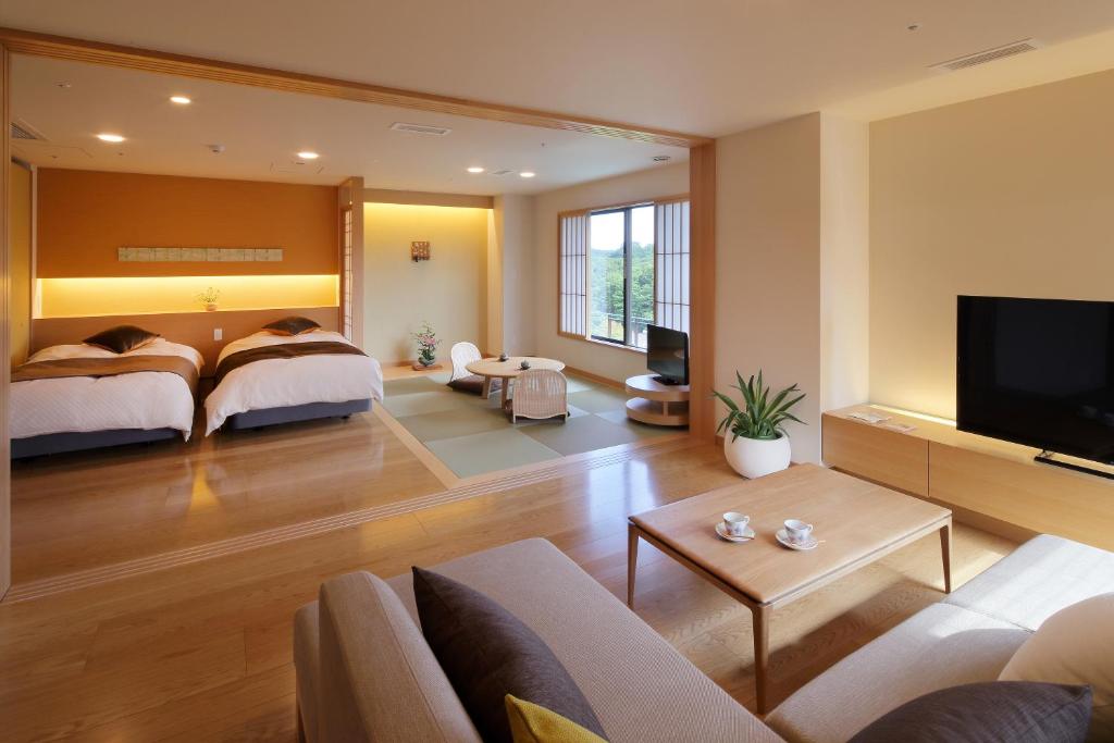 une grande chambre avec un lit et un salon dans l'établissement 仙台秋保温泉 篝火の湯 緑水亭, à Sendai