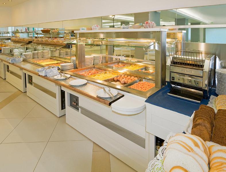 une grande cuisine avec de nombreux plateaux de nourriture dans l'établissement Hotel Bolivar, à Lido di Jesolo 9 autres photos