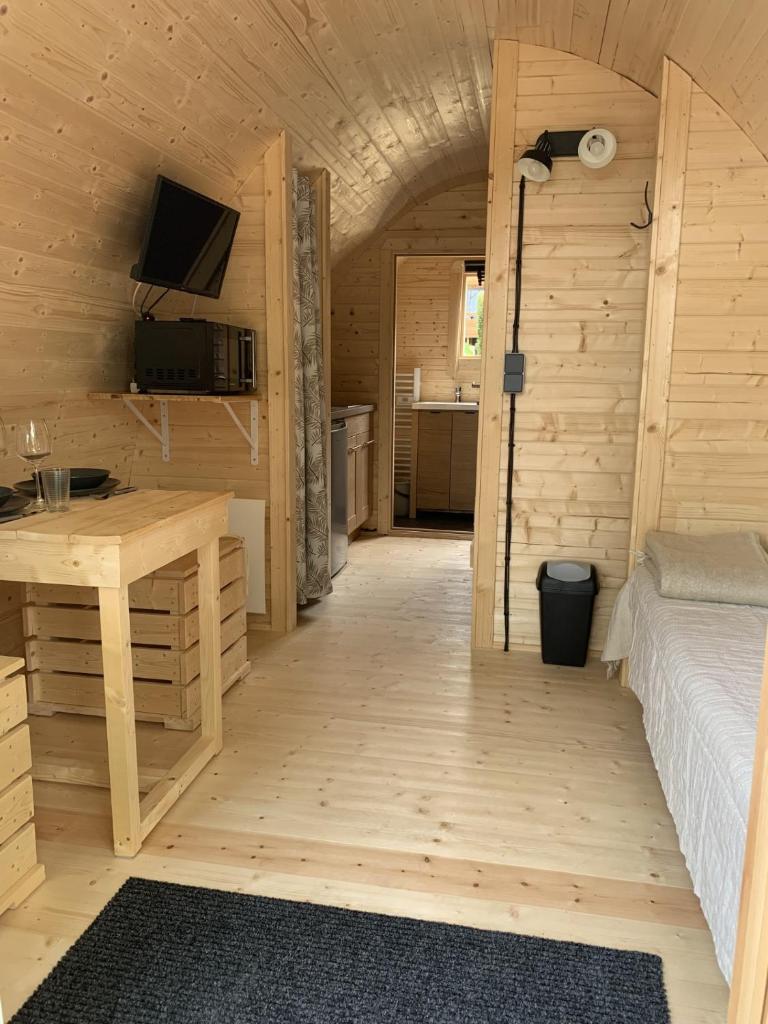 - une chambre avec un lit et un bureau dans une cabine dans l'établissement Domaine Les Nids du Lac, à Sanchey