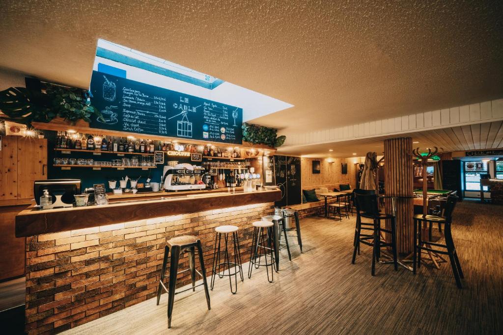un bar avec tabourets de bar dans un restaurant dans l'établissement Résidence Capfun du Téléphérique, Morzine, à Morzine
