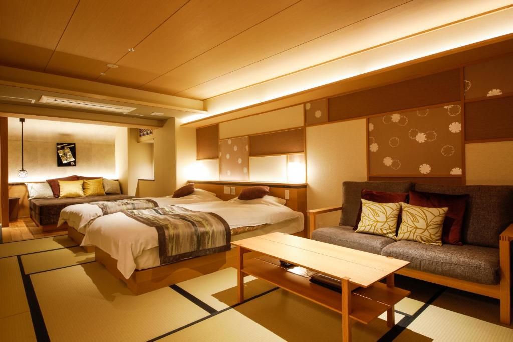 une chambre d'hôtel avec un lit et un canapé dans l'établissement Sun Urashima Yuki no Sato, à Toba