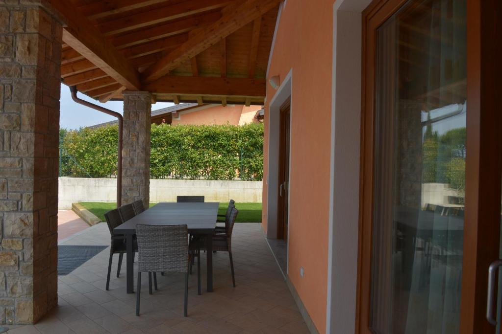 une terrasse avec une table et des chaises dans une maison dans l'établissement Villa Artemia, à Manerba del Garda