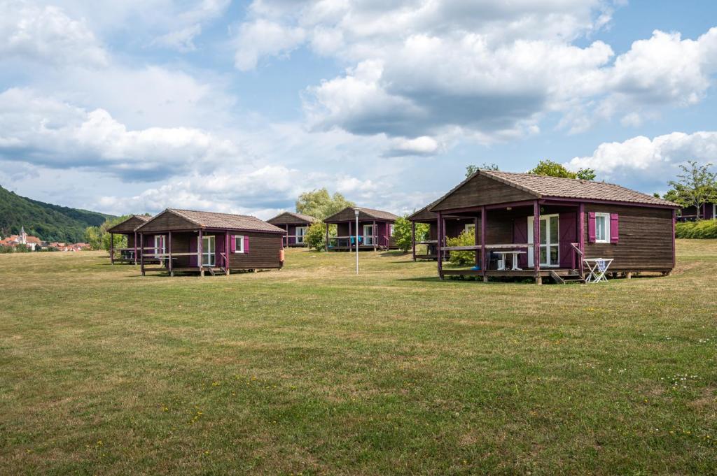 un groupe de cottages dans un champ d'herbe dans l'établissement Camping Les Vosges du Nord, à Oberbronn