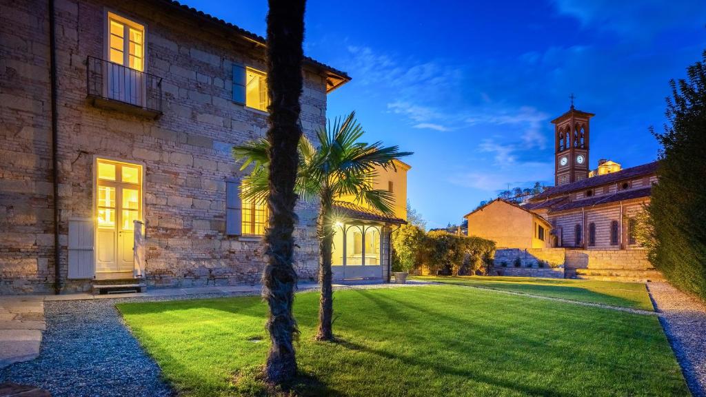 un palmier devant un bâtiment avec une tour d'horloge dans l'établissement PALAZZO POZZO BONELLI 14, Emma Villas, à Ottiglio