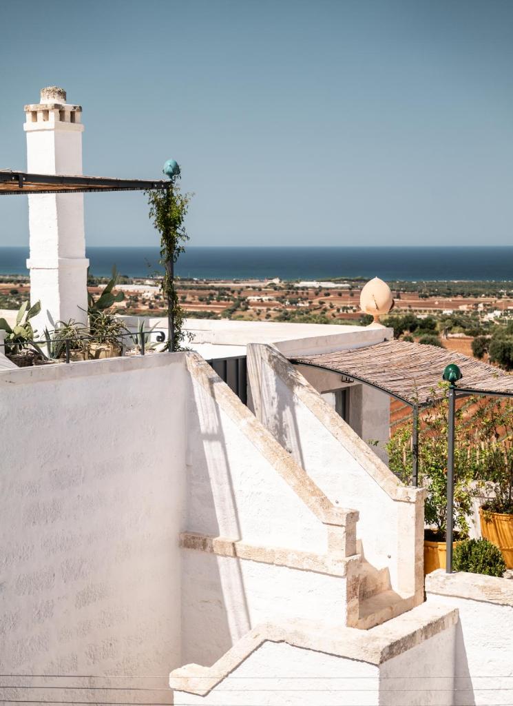 un escalier avec un phare en arrière-plan dans l'établissement Masseria Auraterrae, à Polignano a Mare