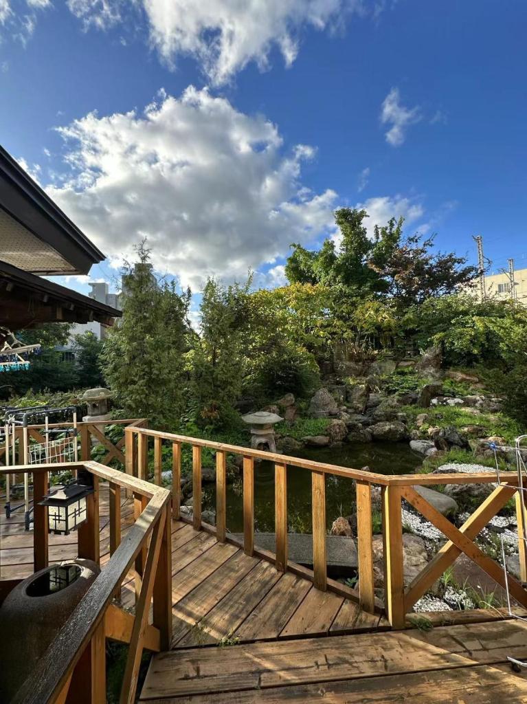 une terrasse en bois avec vue sur un étang dans l'établissement Plum House Otaru, à Otaru