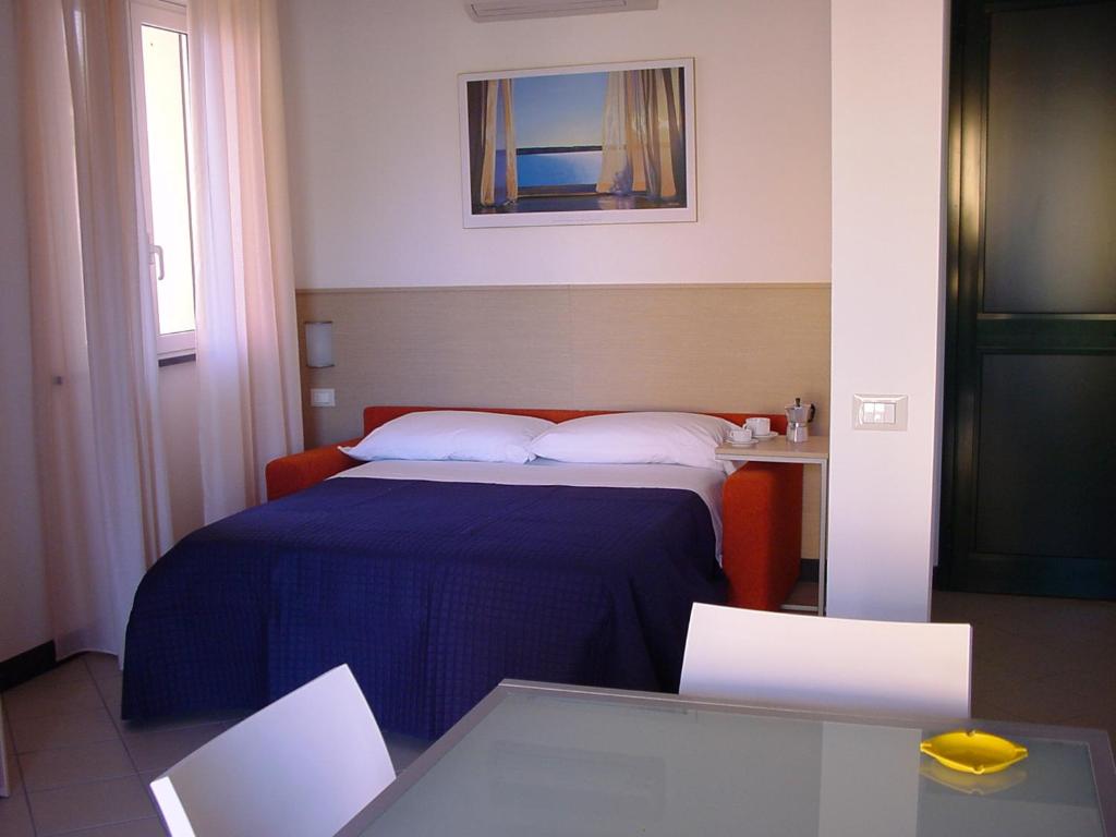 une chambre d'hôtel avec un lit et une table dans l'établissement Residence Borgomare, à Albenga