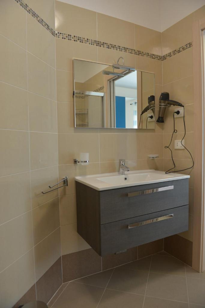 une salle de bain avec un lavabo et un miroir dans l'établissement Villa Artemia, à Manerba del Garda