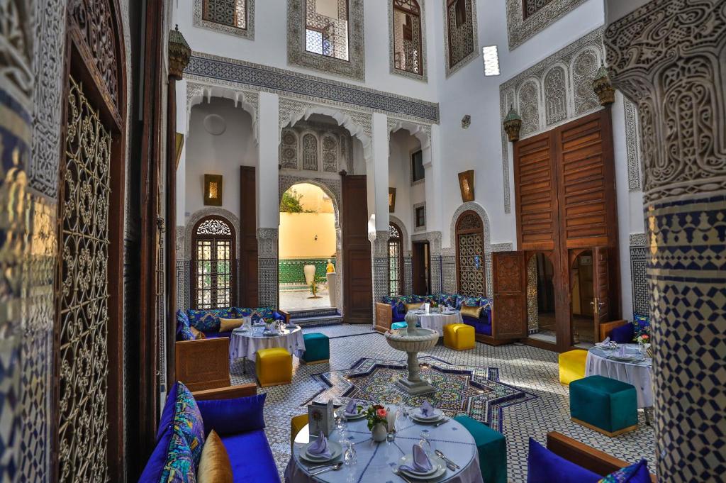 un restaurant avec des tables et des chaises dans un bâtiment dans l'établissement Riad Fes Ziyat & Spa, à Fès