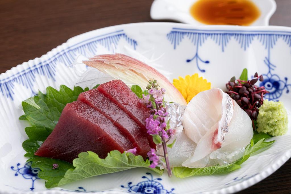 une assiette de denrées alimentaires contenant de la viande et des légumes sur une table dans l'établissement Towa Ryokan, à Kyoto