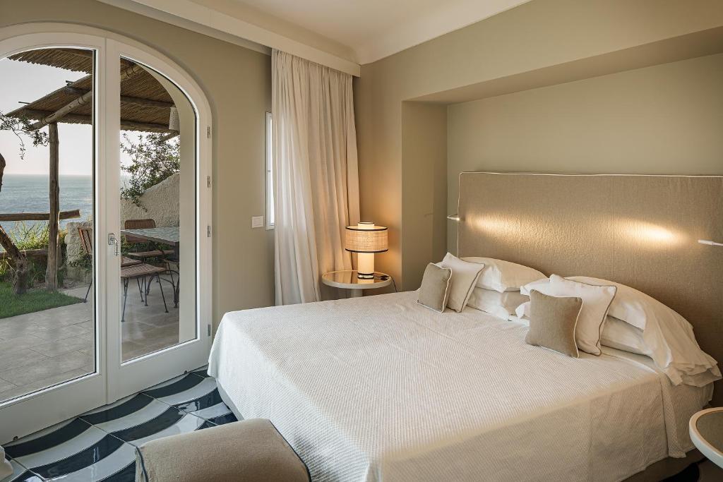 une chambre avec un grand lit et un balcon dans l'établissement Costa Del Capitano Seaside Villas, à Ischia 88 autres photos
