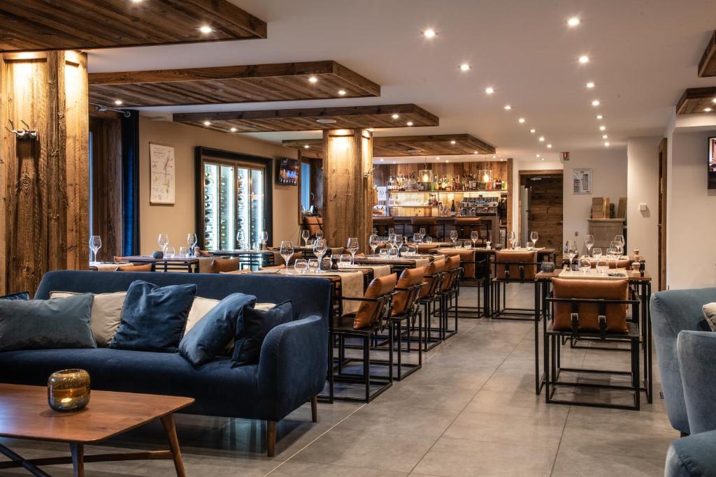 un restaurant avec des canapés et des tables bleus ainsi qu'un bar dans l'établissement Annapurna by Alpine Resorts, aux Gets
