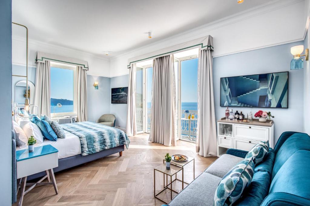 - une chambre avec un canapé bleu et une grande fenêtre dans l'établissement Hotel Mediterraneo, à Sant'Agnello