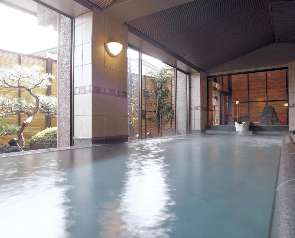 - une piscine dans un bâtiment avec de l'eau à l'étage dans l'établissement Maruei, à Fujikawaguchiko
