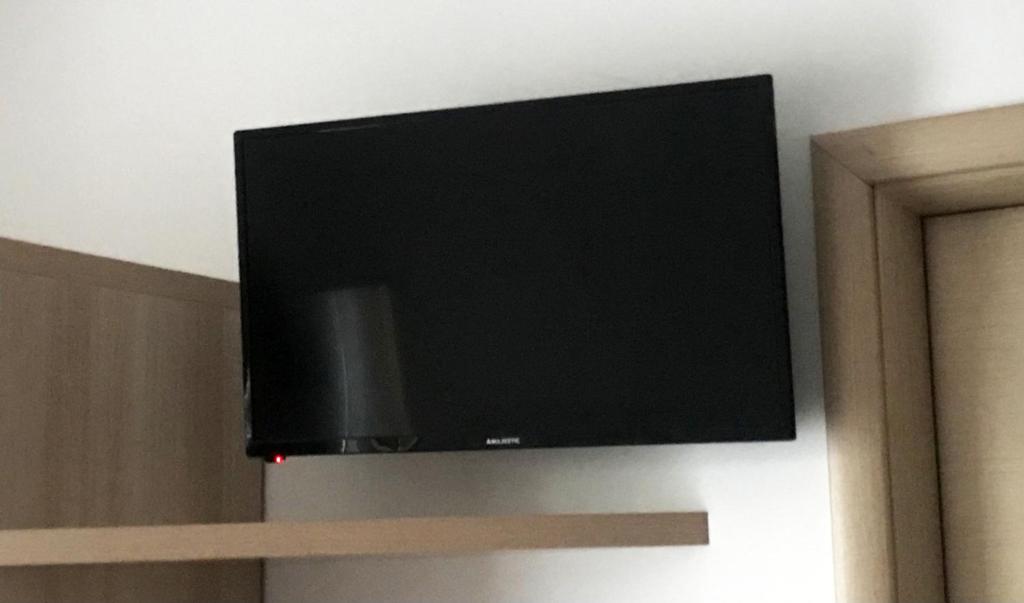 un téléviseur à écran plat accroché au mur dans l'établissement Case Vacanze a Rossano, à Rossano