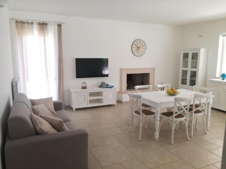 un salon avec un canapé et une table avec des chaises dans l'établissement Villa Greta, à Polignano a Mare