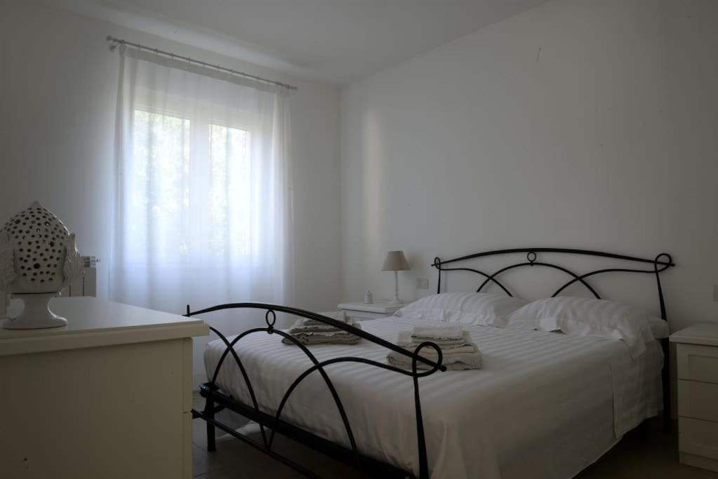 une chambre blanche avec un lit et une fenêtre dans l'établissement Villa Greta, à Polignano a Mare