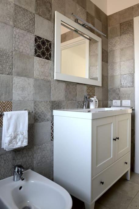 une salle de bain avec un lavabo, des toilettes et un miroir dans l'établissement Villa Greta, à Polignano a Mare