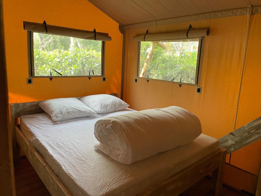 - un lit dans une chambre avec 2 fenêtres dans l'établissement Lodges & Nature - 49, à Avignon 13 autres photos