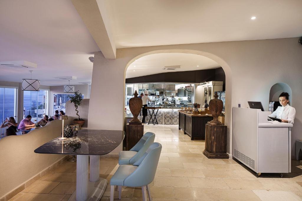 une femme assise à un comptoir dans un restaurant dans l'établissement Therasia Resort Sea and SPA - The Leading Hotels of the World, à Vulcano 184 autres photos