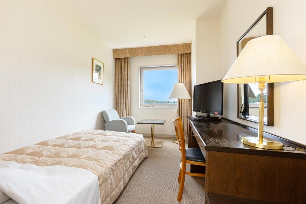 une chambre d'hôtel avec un lit et un bureau dans l'établissement KAMENOI HOTEL Aomori Makado, à Noheji