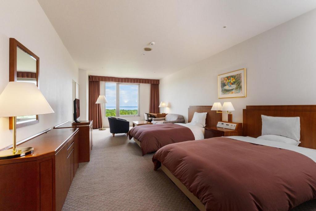 une chambre d'hôtel avec deux lits et un bureau dans l'établissement KAMENOI HOTEL Aomori Makado, à Noheji 37 autres photos